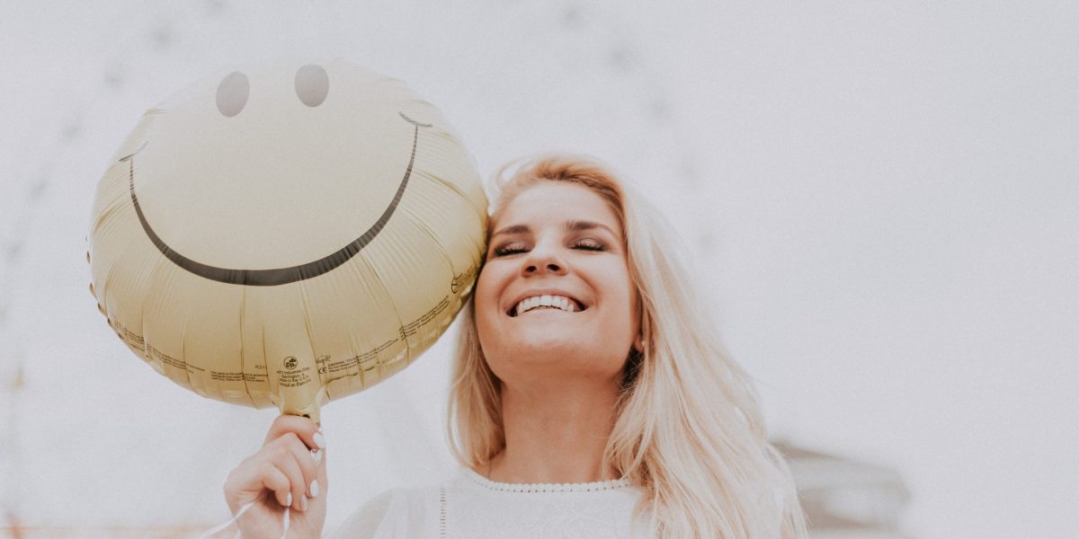 Mujer rubia con sonrisa feliz por una buena estética dental